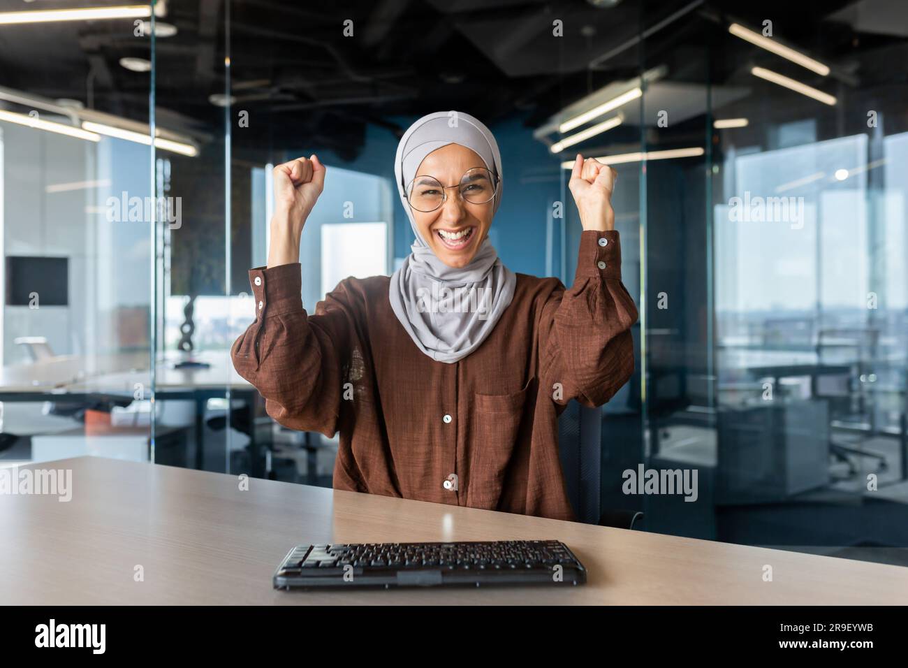 Portrait of happy young muslim business woman in hijab sitting in ...