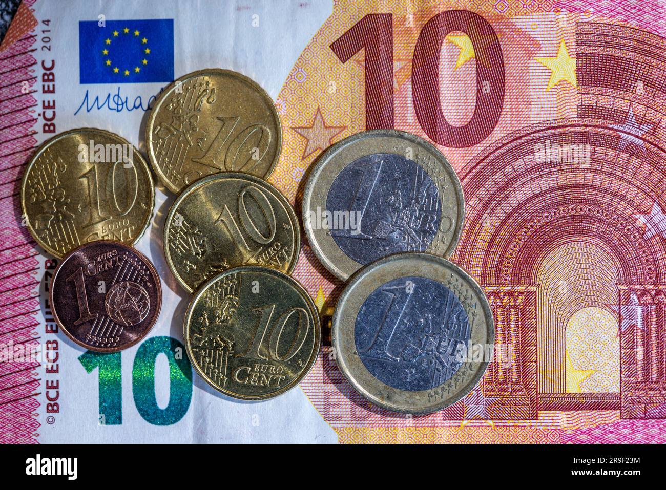 Berlin, Germany. 26th June, 2023. A banknote and euro coins with a value of  12.41 euros lie on a table. The general statutory minimum wage in Germany  is to rise from 12.00