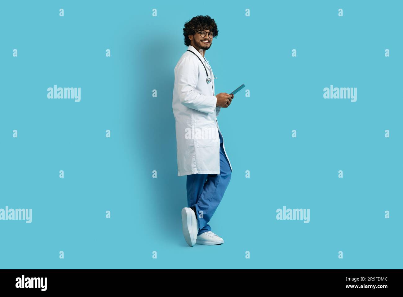 Happy young indian doctor using digital tablet, copy space Stock Photo