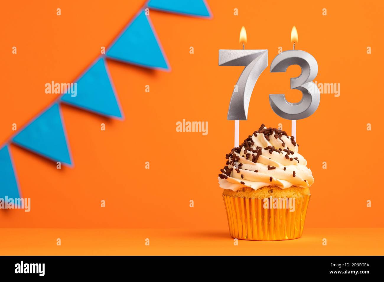 Candle number 73 - Cake birthday in orange background Stock Photo