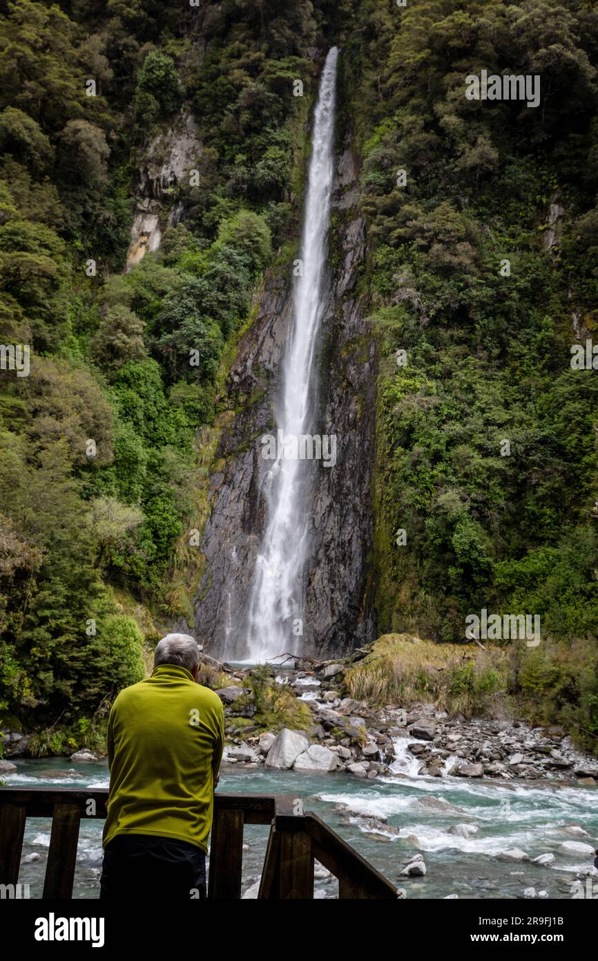 Tourists at Thunder Creek Falls in the Haast River Pass Valley of New Zealand South Island in Mount Aspiring National Park. Photo: Rob Watkins Stock Photo