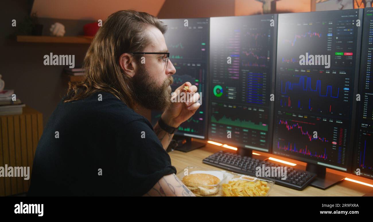 Concentrated trader watches real-time stocks, exchange market charts on  multi-monitor computer workstation, types on keyboard. Man works remotely  in investment at home office. Cryptocurrency trading Stock Photo - Alamy