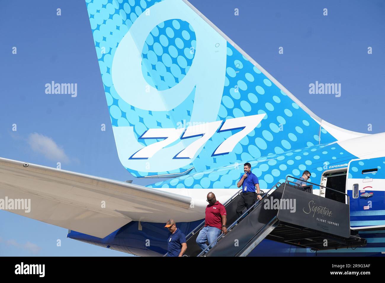 Visitors walk past the tail section as they leave a Boeing 777-9, commercial jet that is in St. Louis for a layover at St. Louis-Lambert International Airport in St. Louis on Monday, June 26, 2023. The 777-9 is the only Boeing commercial airplane with St. Louis- made parts on the aircraft. Boeing employees will spend the day touring the aircraft, seeing it for the first time since production began. Boeing employees in St. Louis produce the 777-9's folding wing tip, moveable trailing edge and fixed leading edge on the wings, as well as the rudder and elevator on the empennage. Photo by Bill Gre Stock Photo