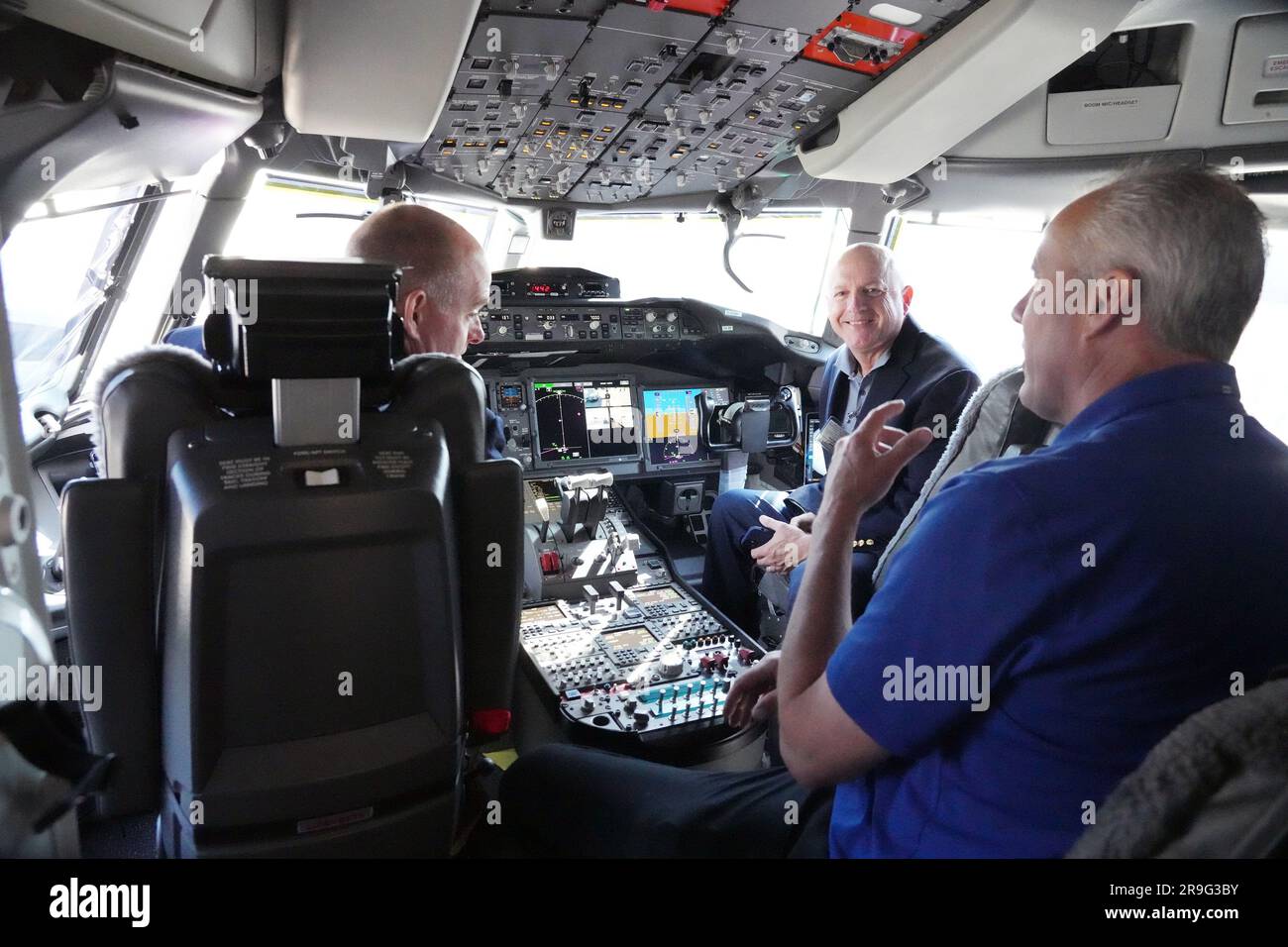 Pilot Ted Grady (R) talks with visitors in the flight deck of his Boeing 777-9, commercial jet that is in St. Louis for a layover at St. Louis-Lambert International Airport in St. Louis on Monday, June 26, 2023. The 777-9 is the only Boeing commercial airplane with St. Louis- made parts on the aircraft. Boeing employees will spend the day touring the aircraft, seeing it for the first time since production began. Boeing employees in St. Louis produce the 777-9's folding wing tip, moveable trailing edge and fixed leading edge on the wings, as well as the rudder and elevator on the empennage. Pho Stock Photo