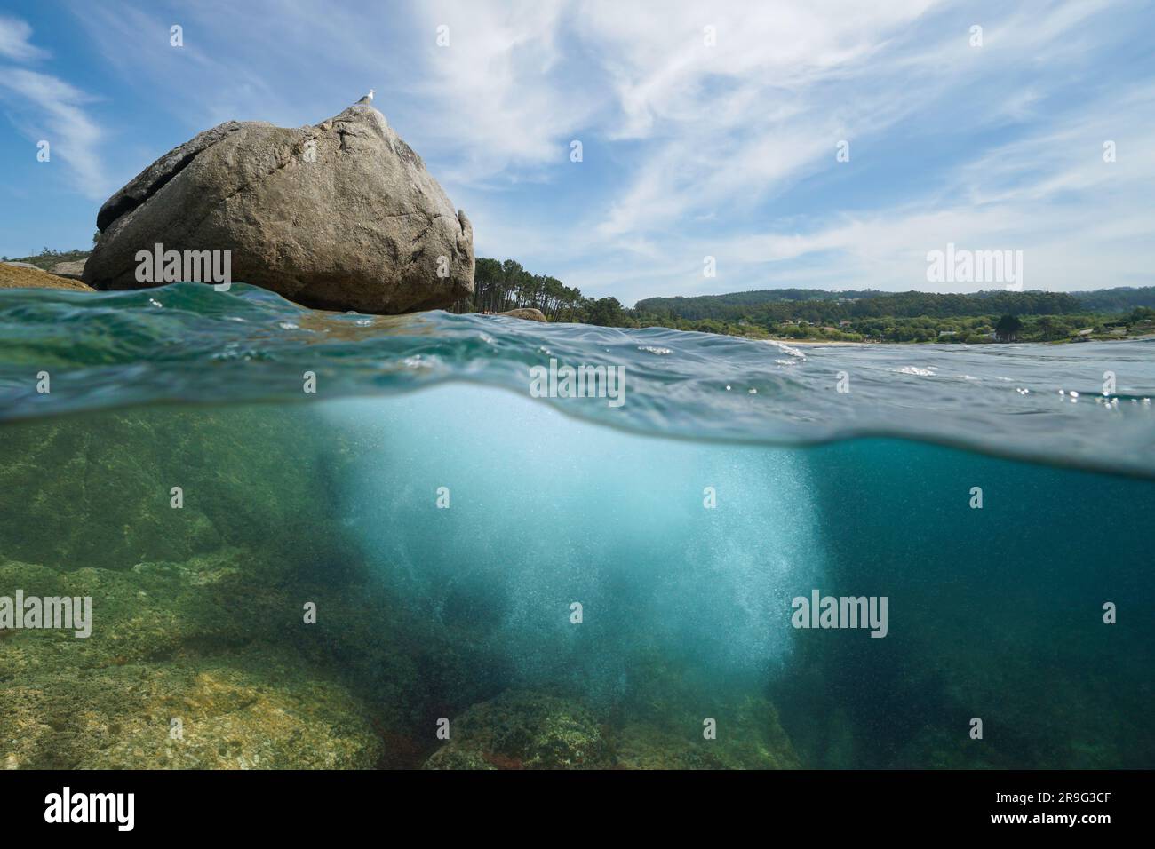 Sea Rias Rock on the ocean shore with sea foam bubbles underwater, split view ...