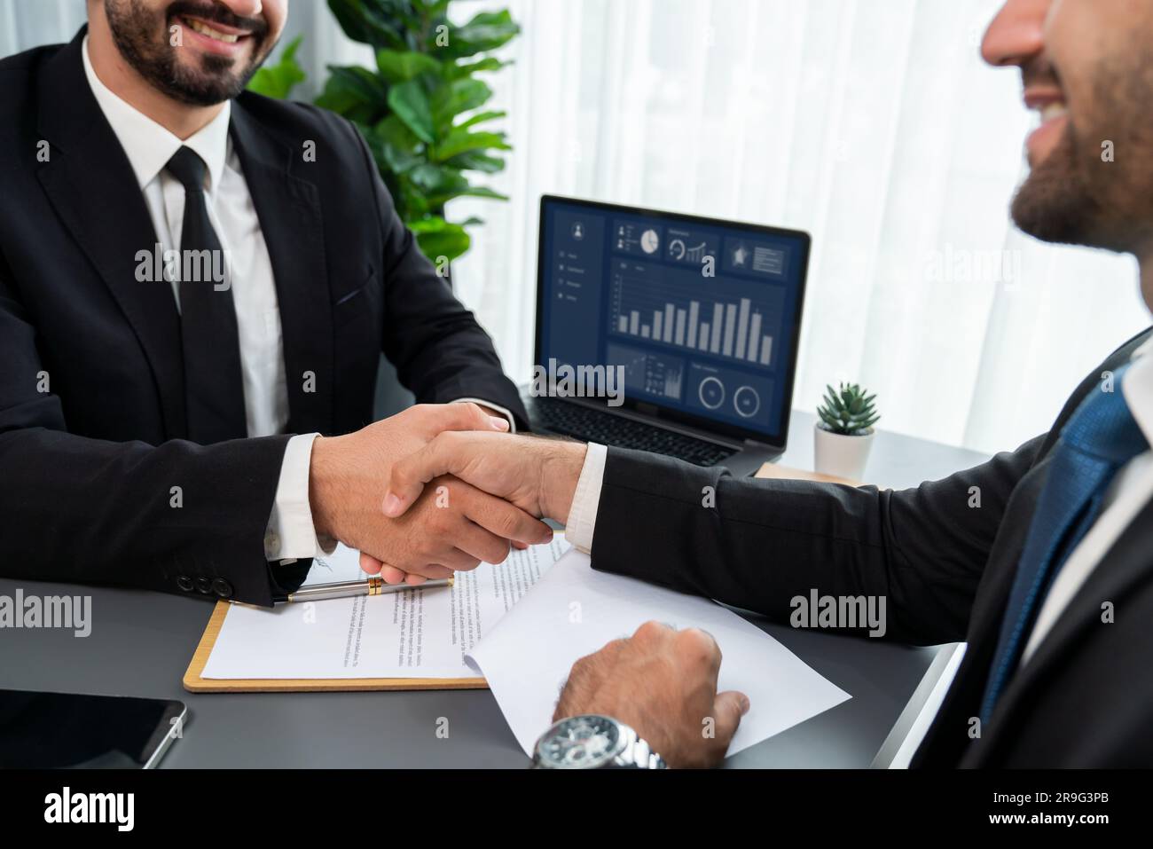 Two professionals successfully close business deal with closeup