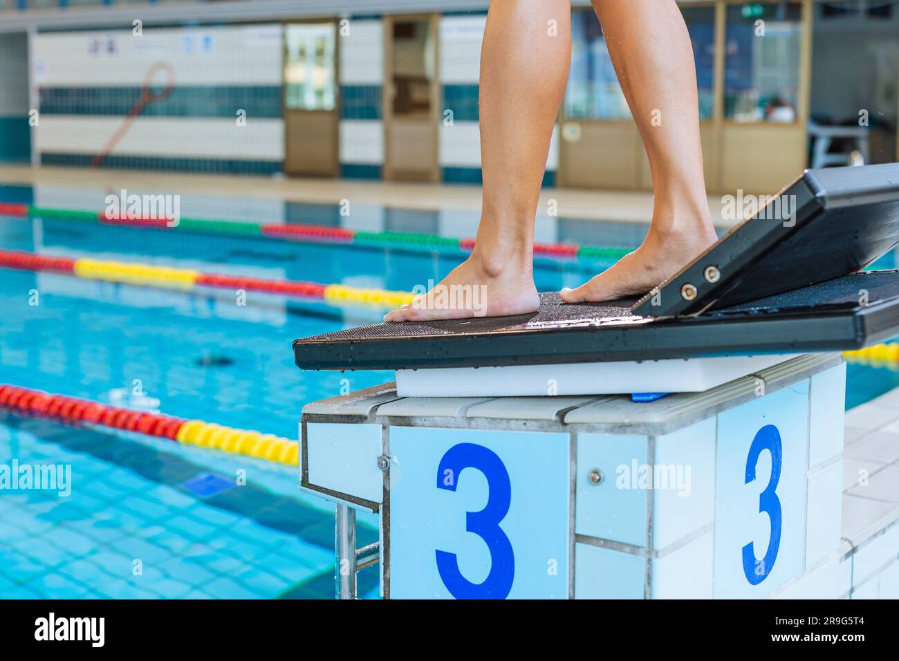 Female swimmer body in swimming start position and diving off the