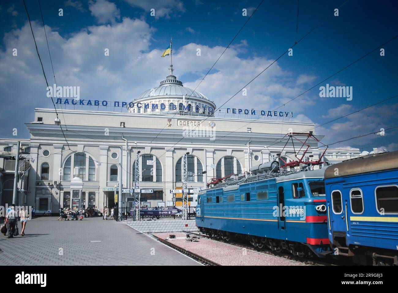 Picture of the Odessa train station with passengers passing by and a