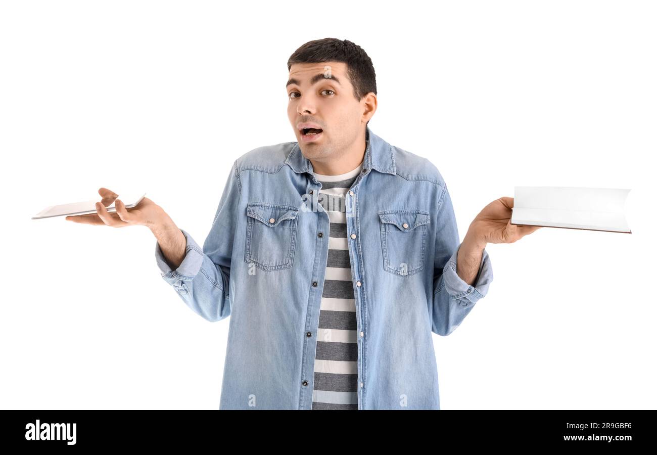 Confused young man with tablet computer and book on white background ...