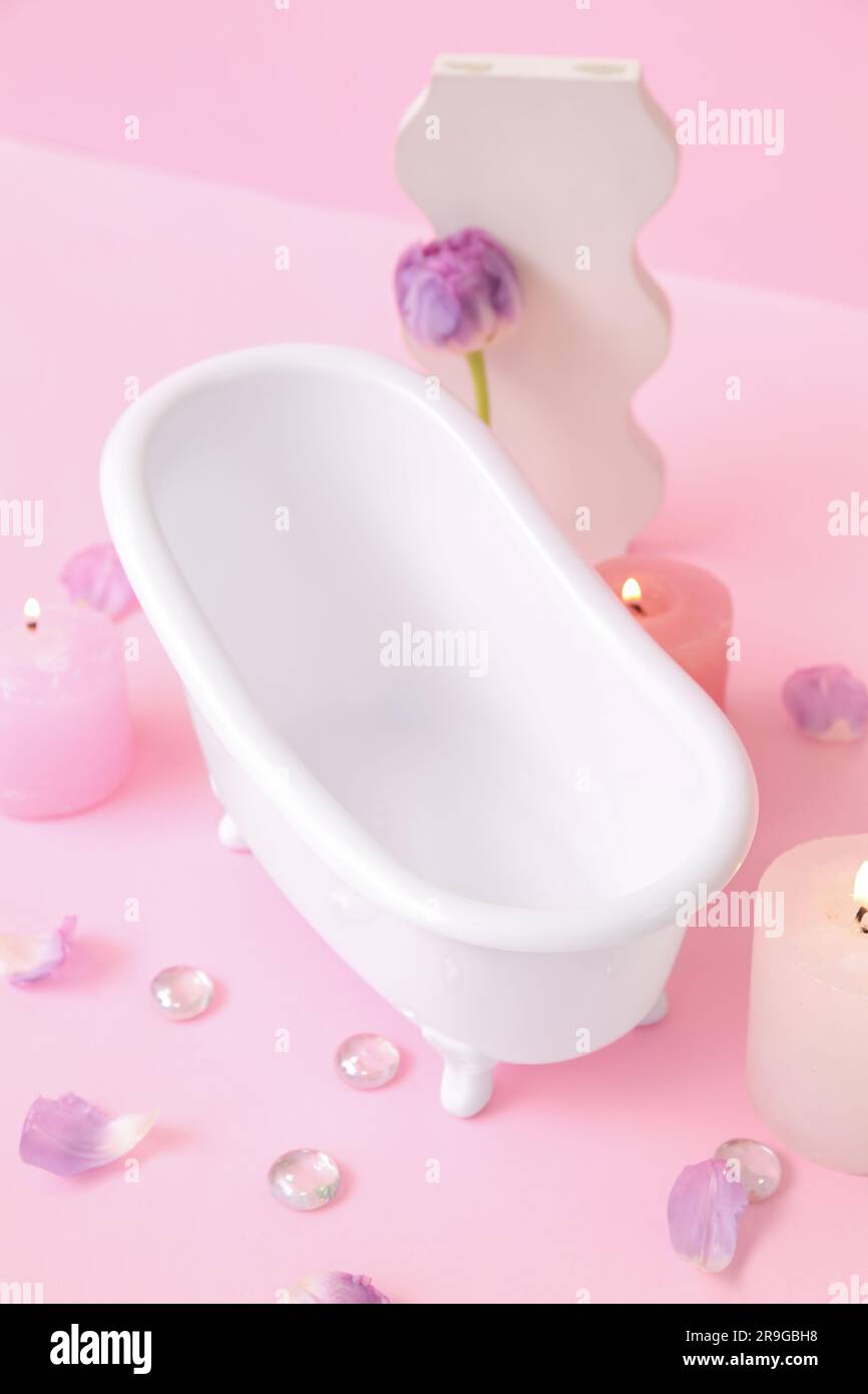 https://c8.alamy.com/comp/2R9GBH8/small-bathtub-burning-candles-and-decor-on-pink-background-2R9GBH8.jpg