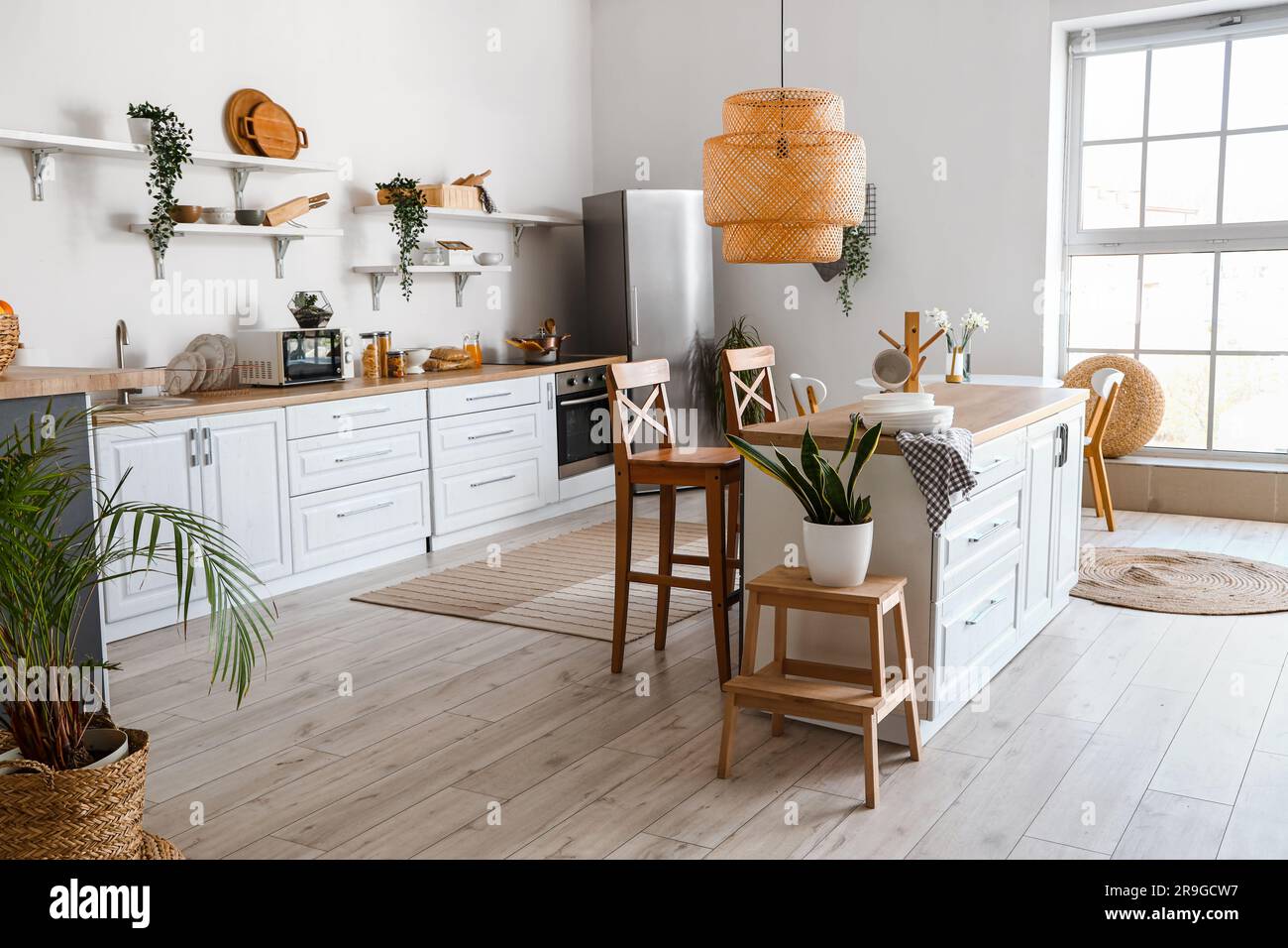 Interior of light kitchen with stylish fridge, counters, shelves and ...
