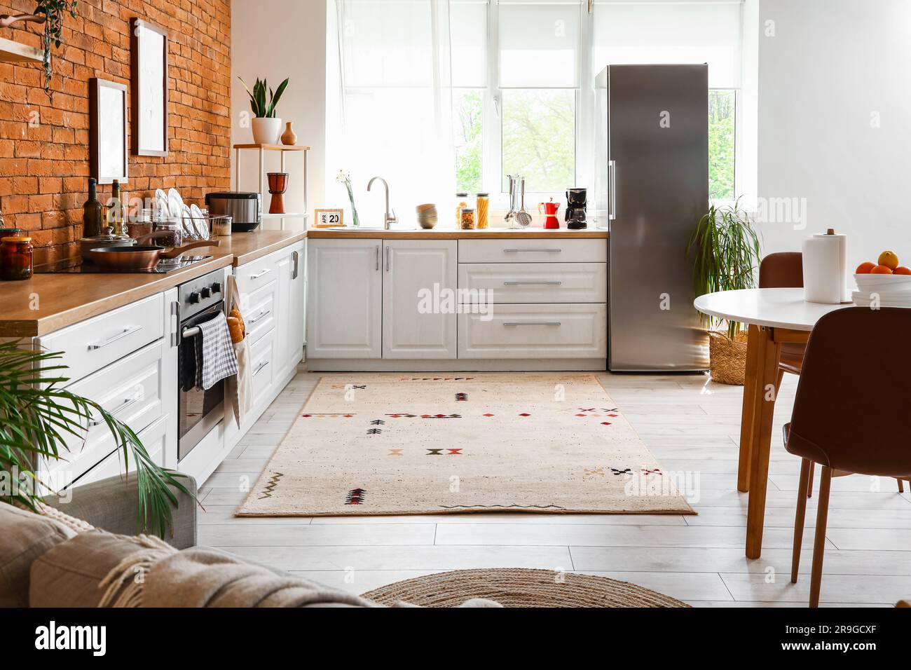 Interior of kitchen with stylish fridge, counters, window and table ...