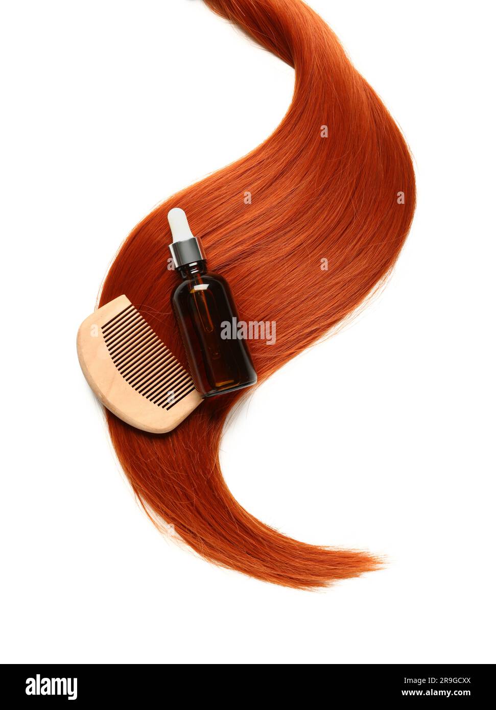 Ginger hair strand, comb and bottle of cosmetic product on white