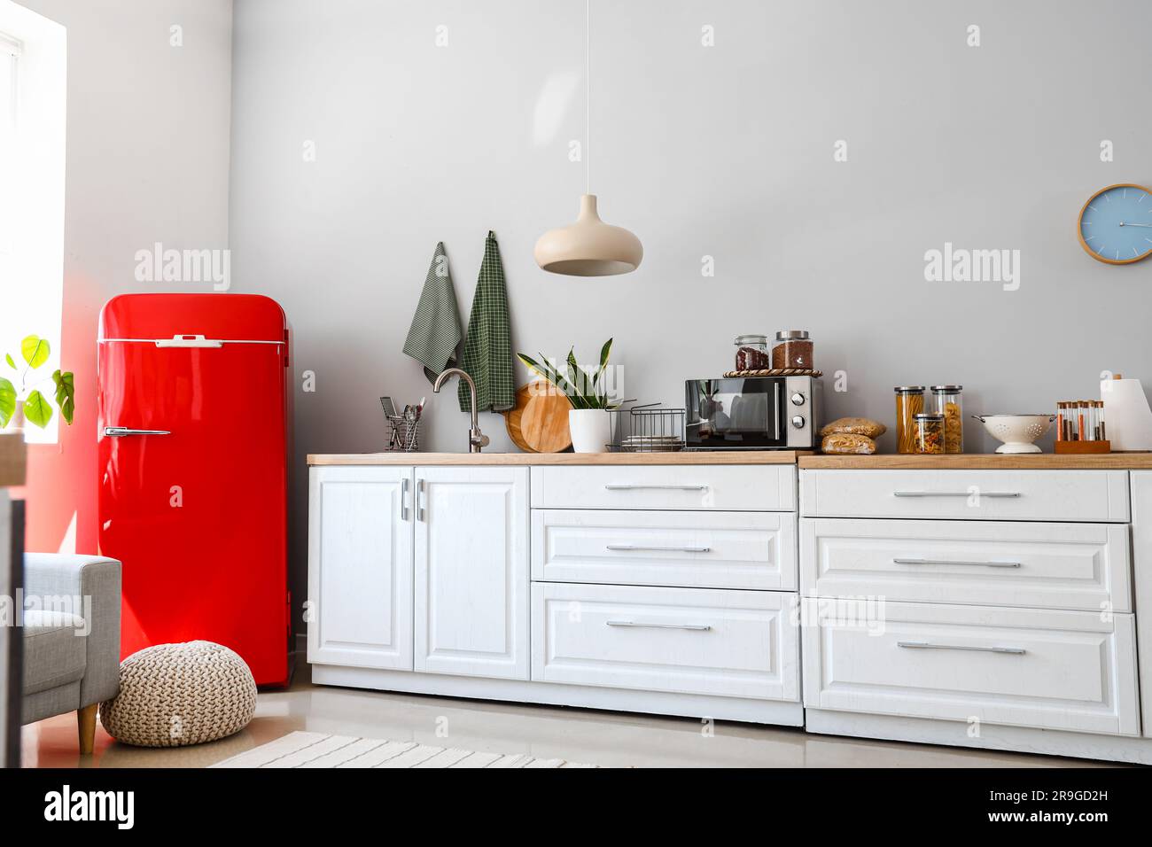 Interior of light kitchen with red fridge, counters and pouf Stock ...