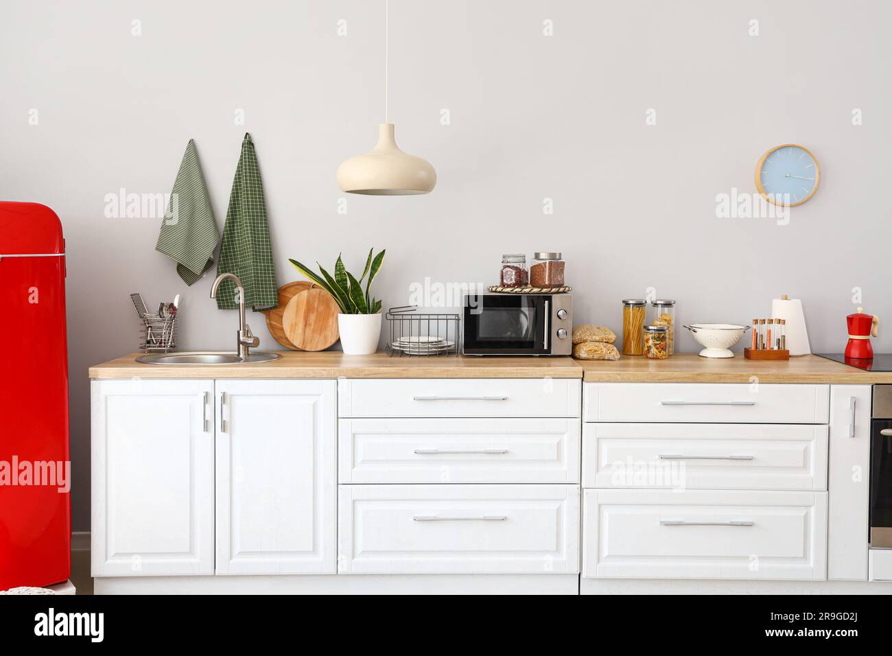 Interior of light kitchen with red fridge and counters Stock Photo - Alamy