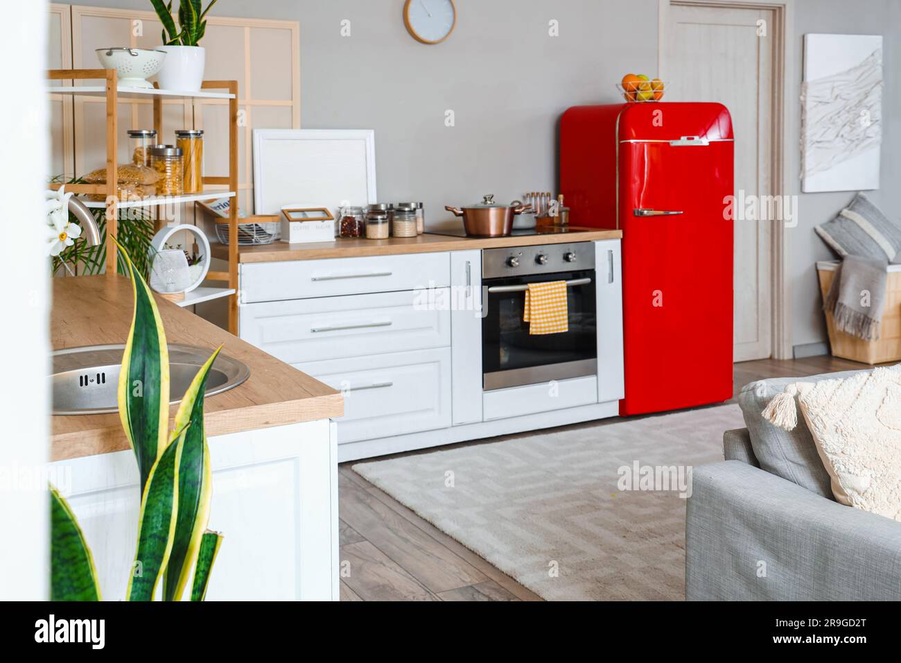 Interior of kitchen with red fridge, counters, sofa and shelving unit