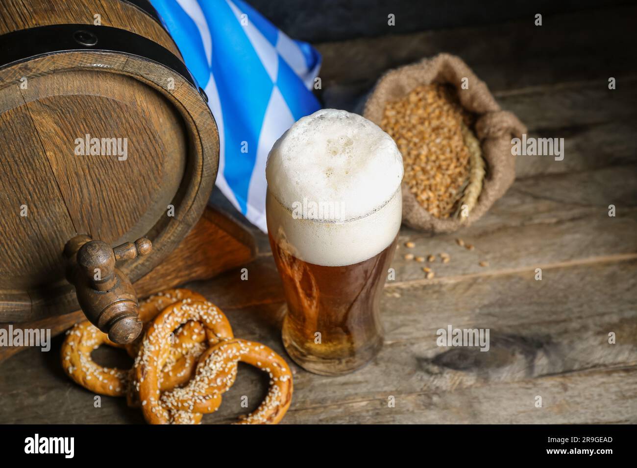 https://c8.alamy.com/comp/2R9GEAD/glass-of-cold-beer-pretzels-and-barrel-on-wooden-background-oktoberfest-celebration-2R9GEAD.jpg