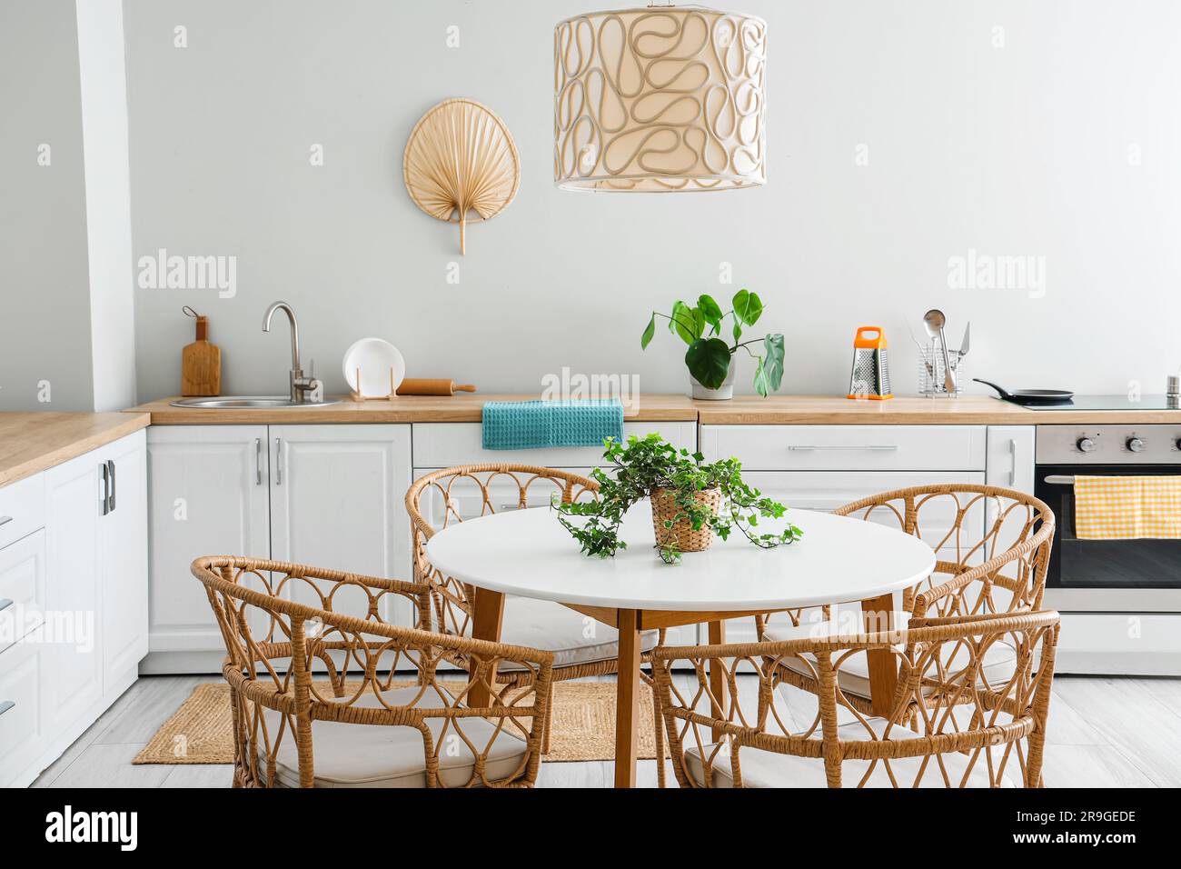 Interior of light kitchen with white counters, electric oven and dining ...