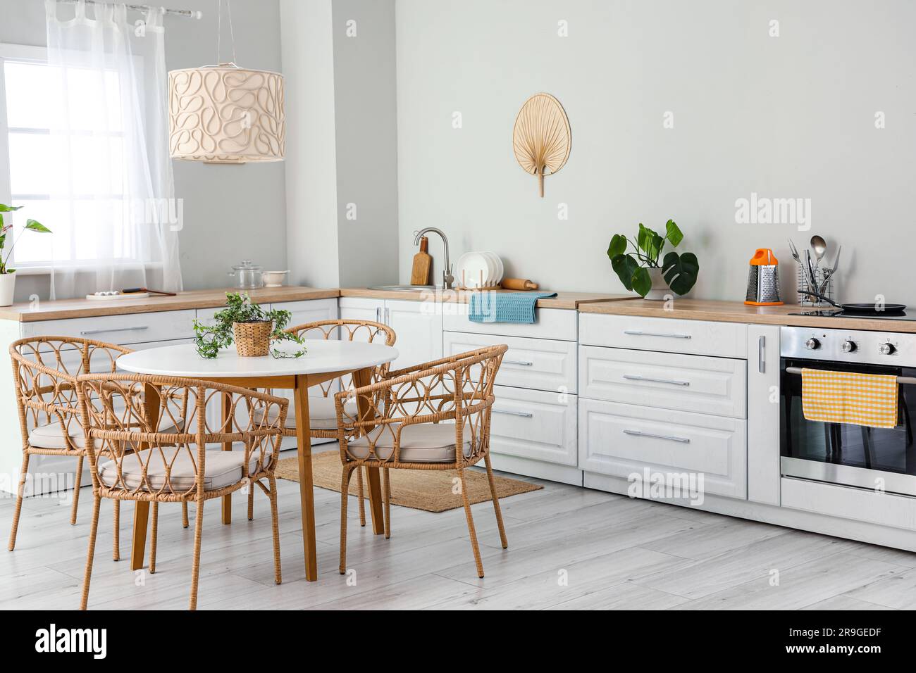Interior of light kitchen with white counters, electric oven and dining ...