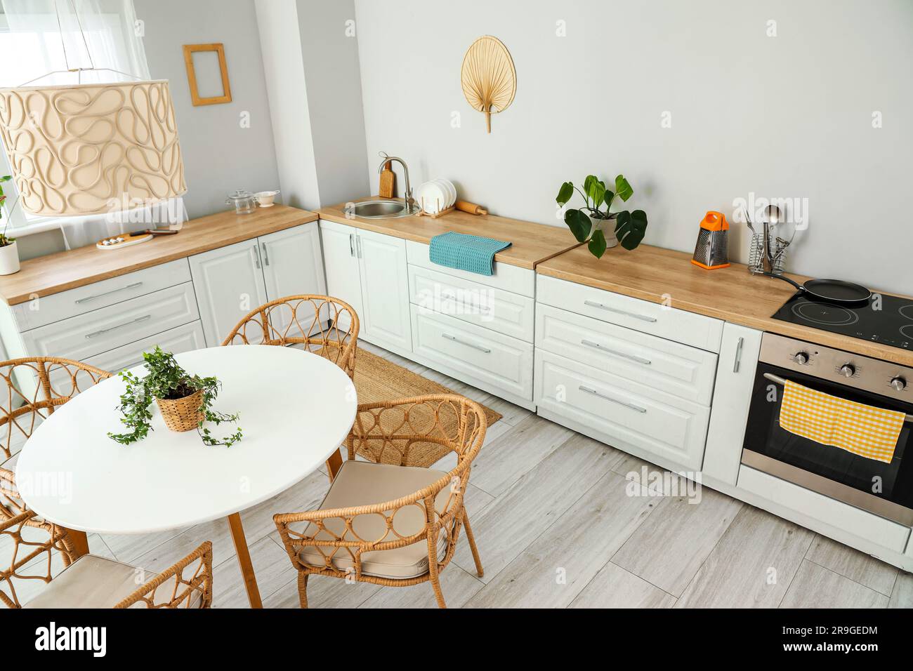 Interior of light kitchen with white counters, electric oven and dining ...