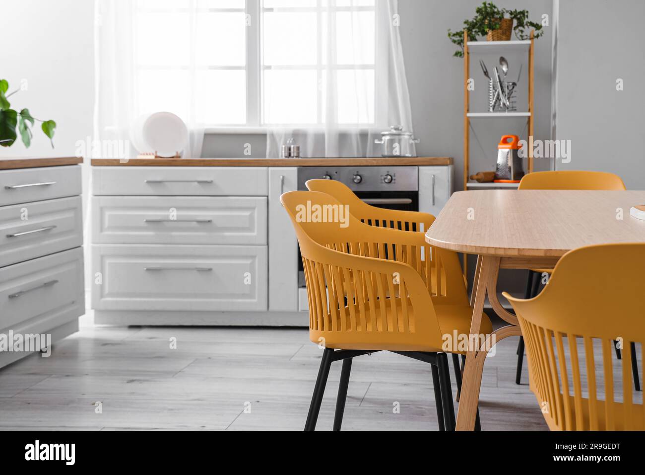 Interior of light kitchen with white counters and dining table Stock ...