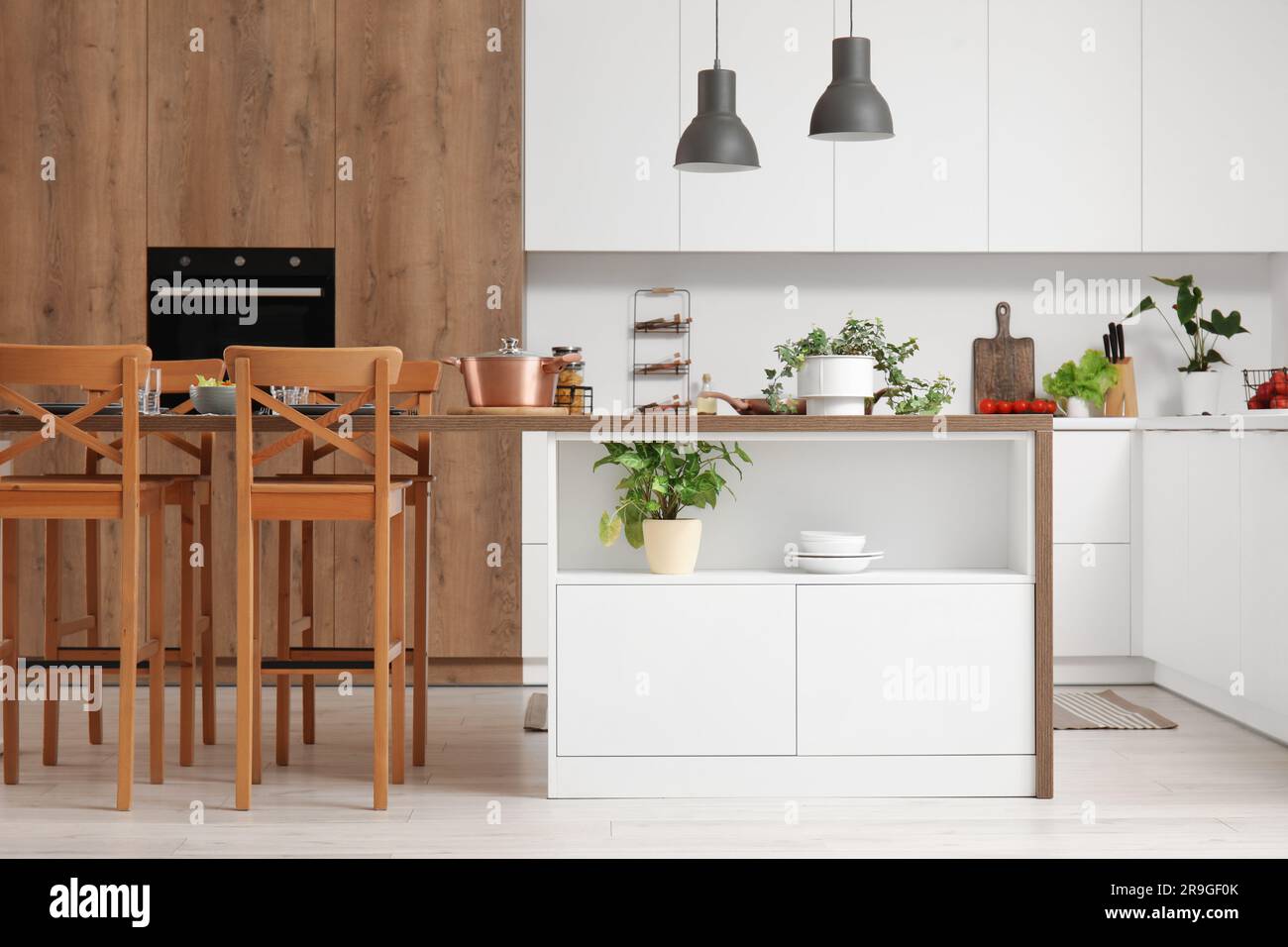 Interior of modern kitchen with island table and white counters Stock ...