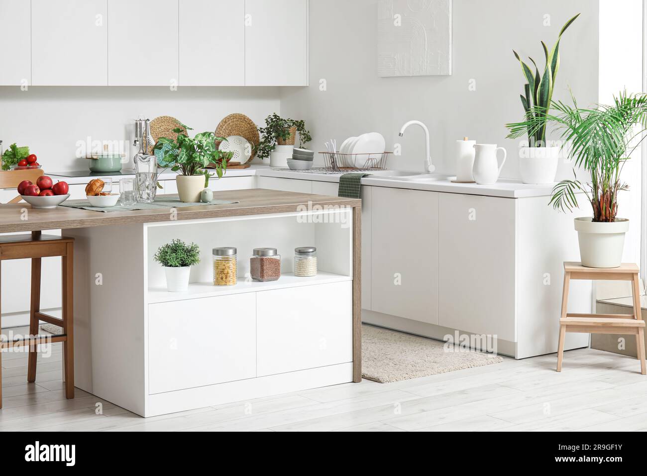 Interior of modern kitchen with island table and white counters Stock ...