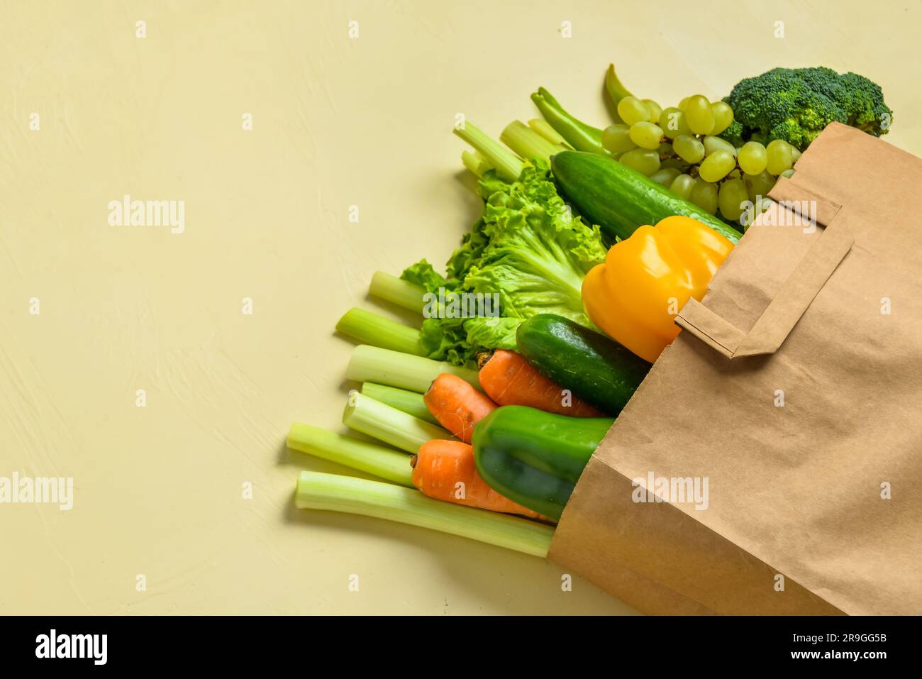 Paper bag with fresh vegetables and fruits on beige background Stock ...
