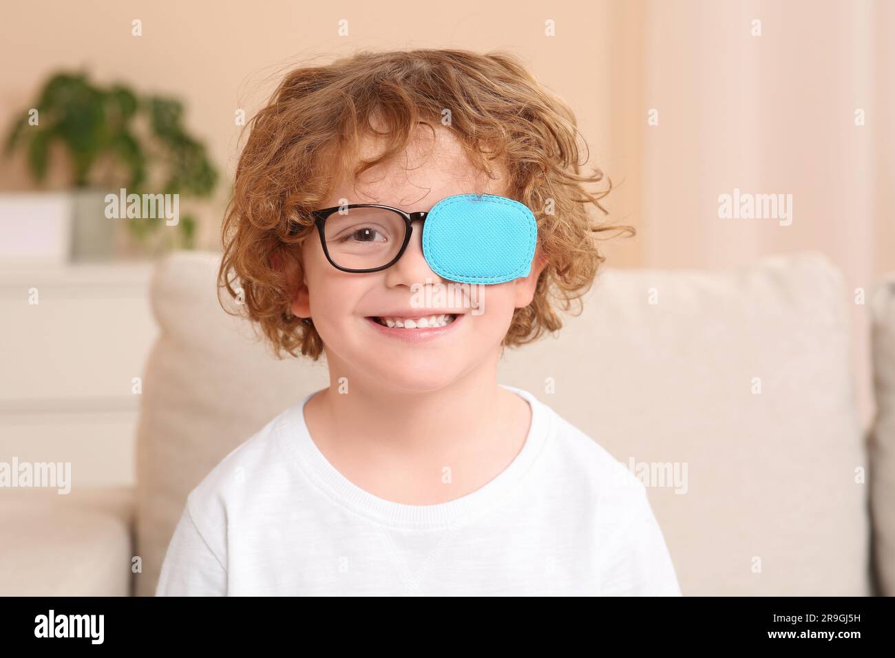Boy wearing eye patch accroché à partir de la branche de l'arbre Photo  Stock - Alamy
