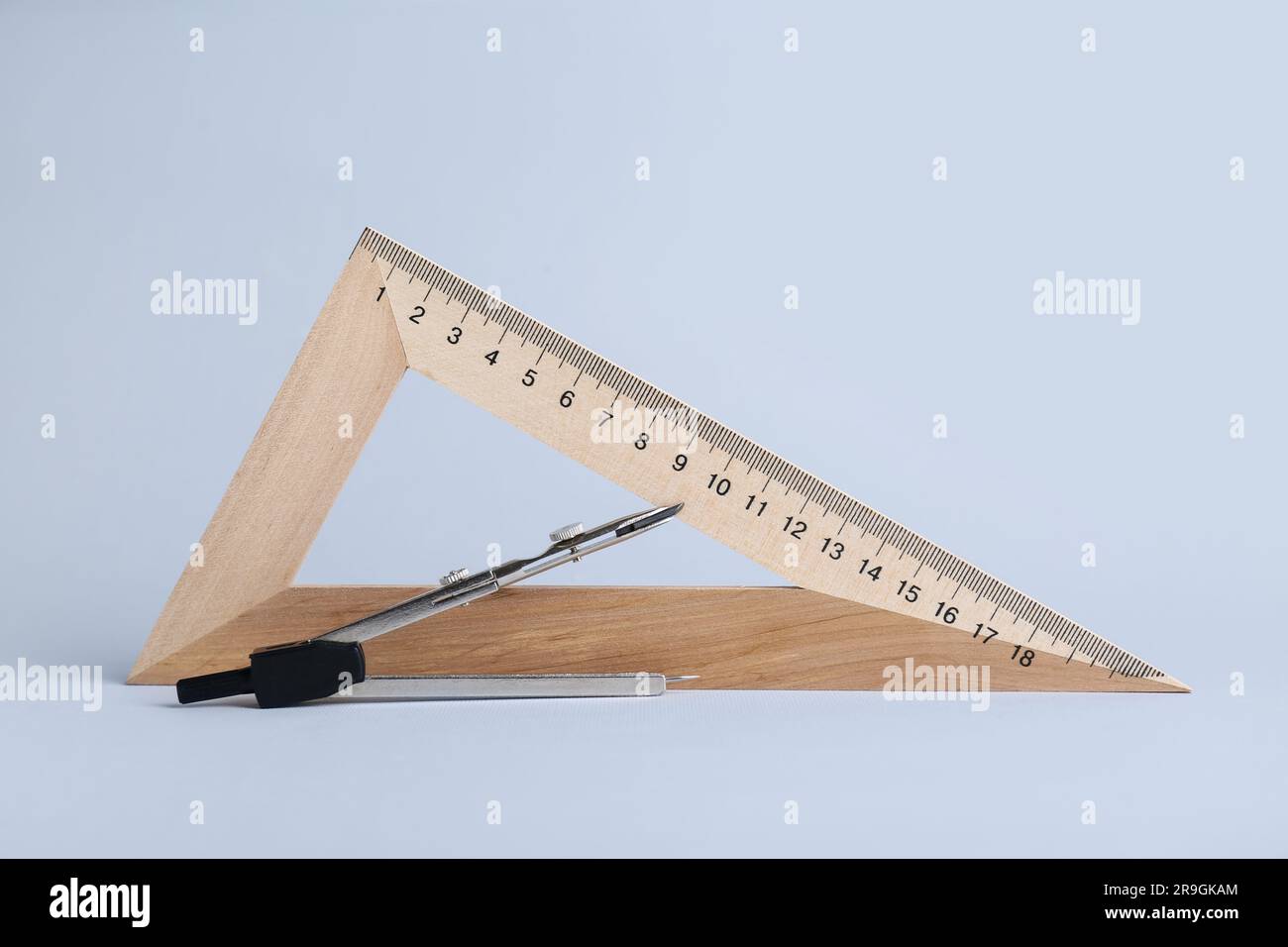 Triangle ruler and compass on white background Stock Photo - Alamy