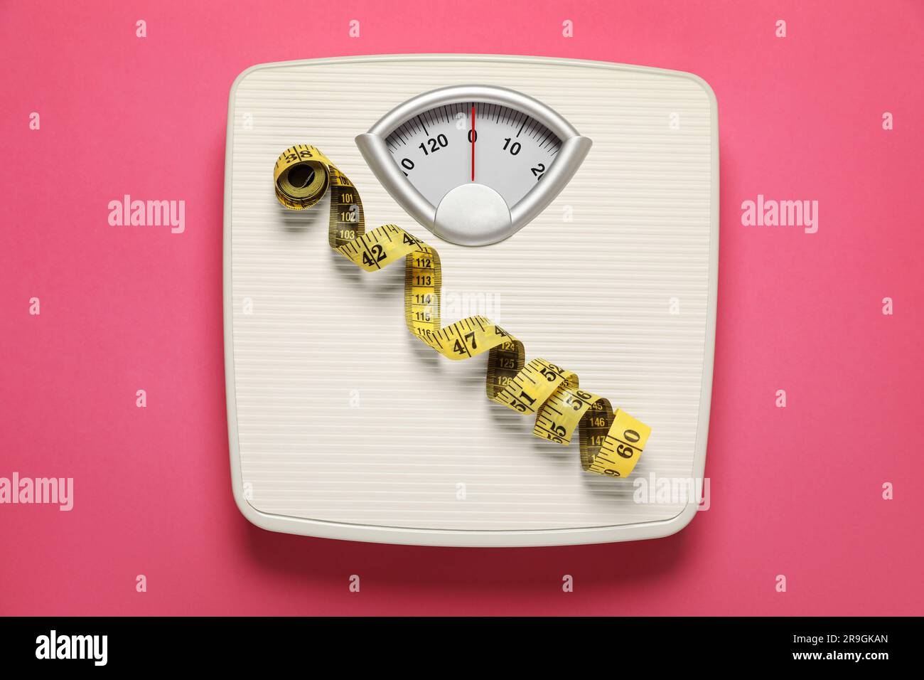 Measure Tape With Dumbbells And Weight Scale On The Pink