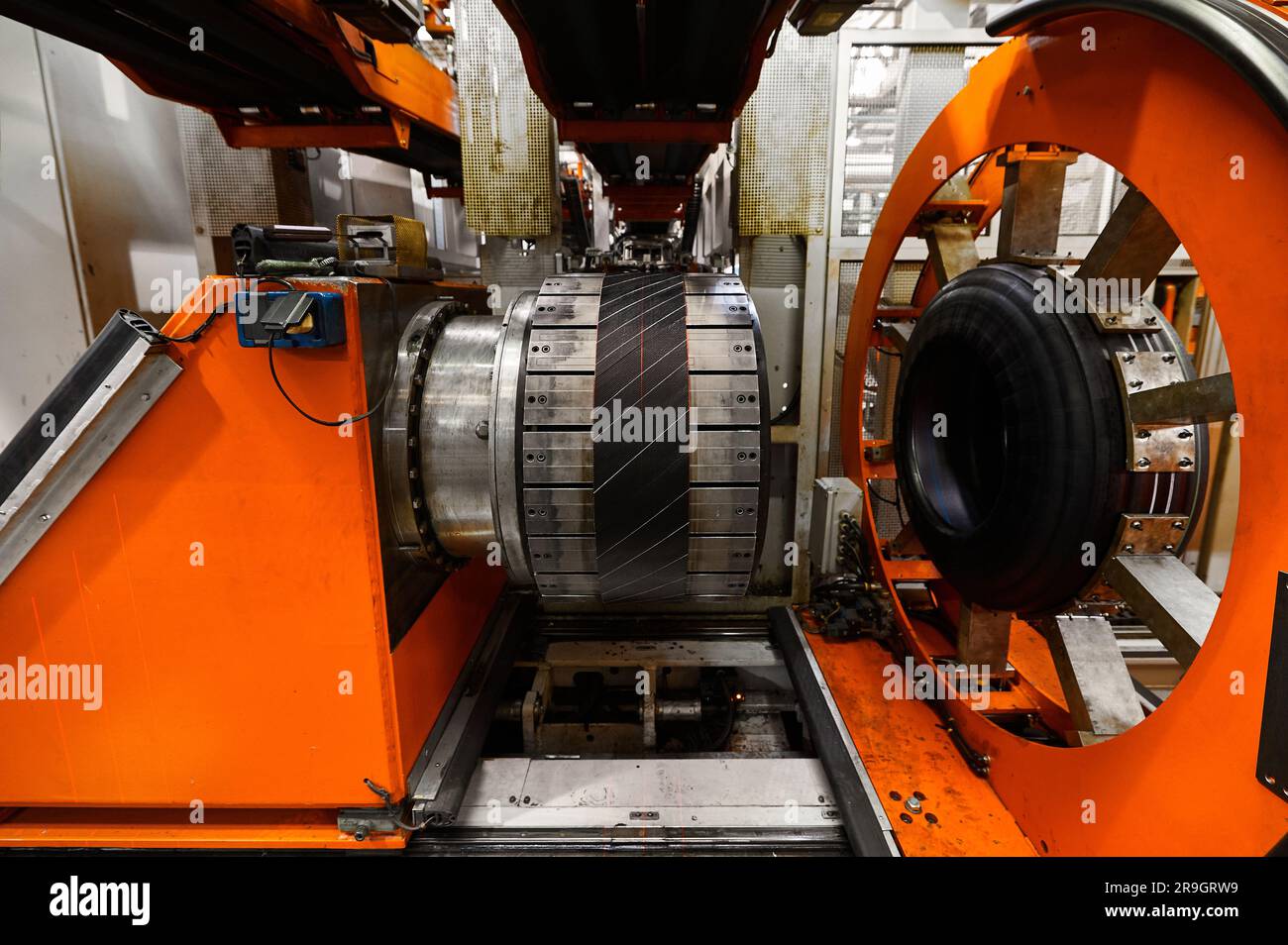 Rolling drum with rubber layers to form car tire at plant Stock Photo