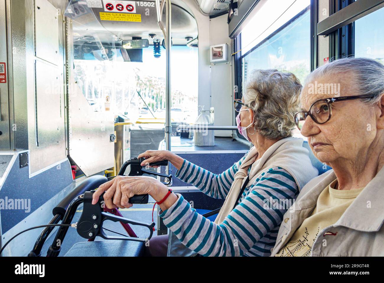 Miami Beach Florida,Miami-Dade Metrobus public bus transportation inside interior cabin senior women sitting walker Stock Photo
