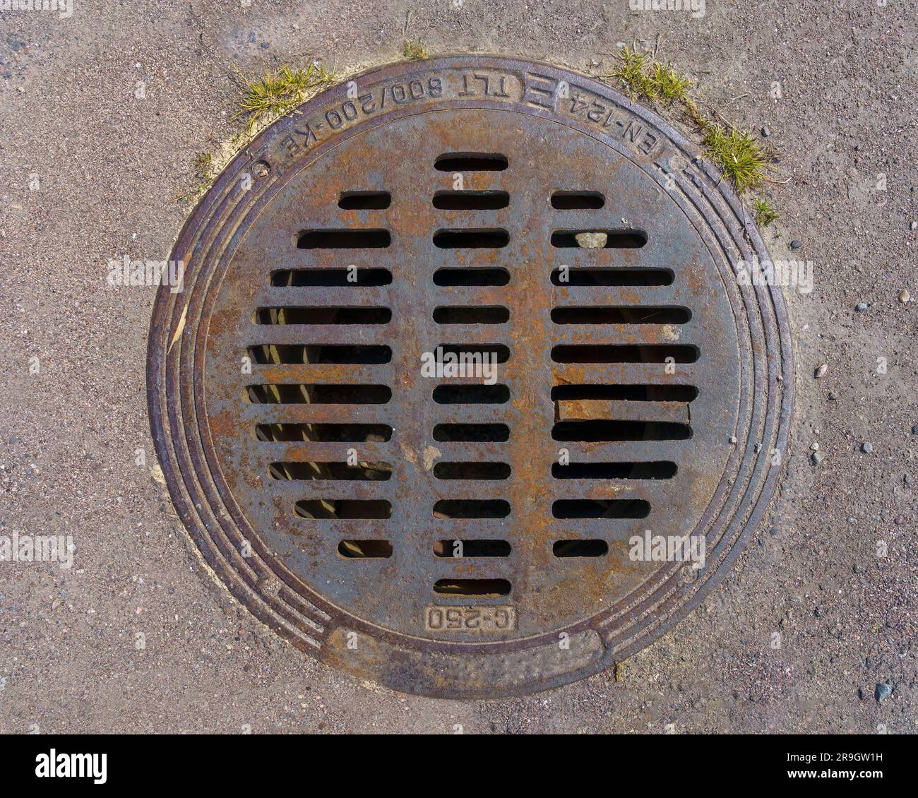 Round metal storm drain cover on asphalt, top view close up Stock Photo