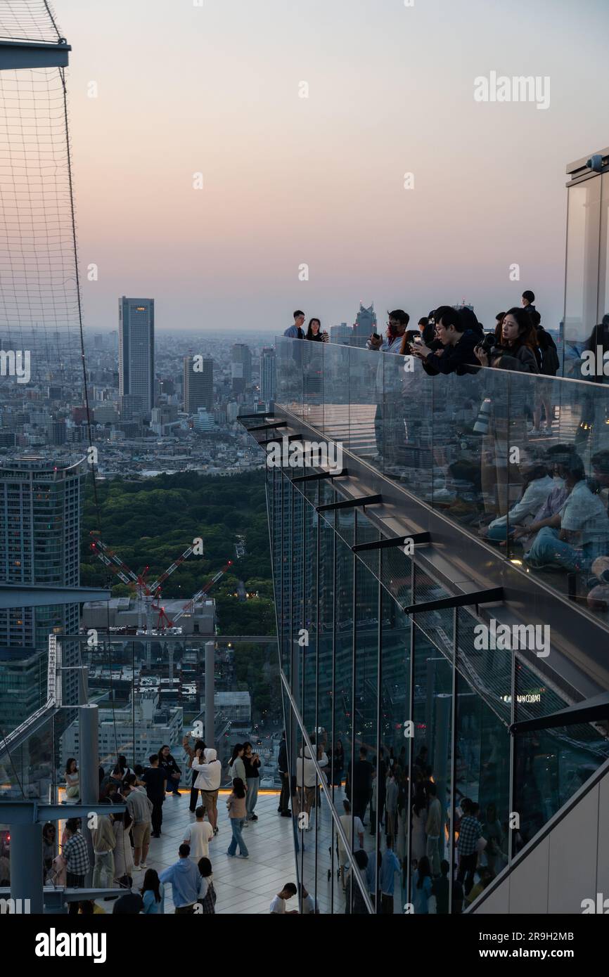 Tokyo, Japan - May 04 2023: People enjoy the sunset over Tokyo cityscape from the Shibuya Sky observation desk in Japan capital city. Stock Photo