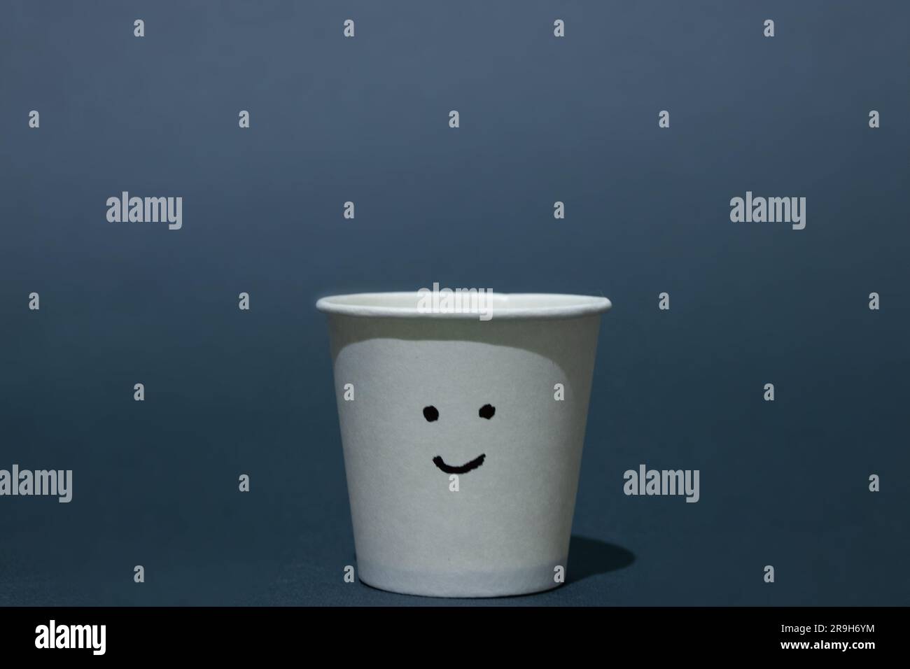 empty paper cup with painted smiley on a dark background Stock Photo ...