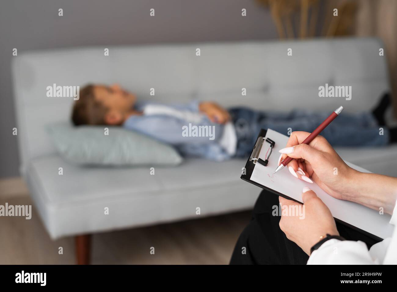 Professional psychiatrist working with her patient teen boy and making