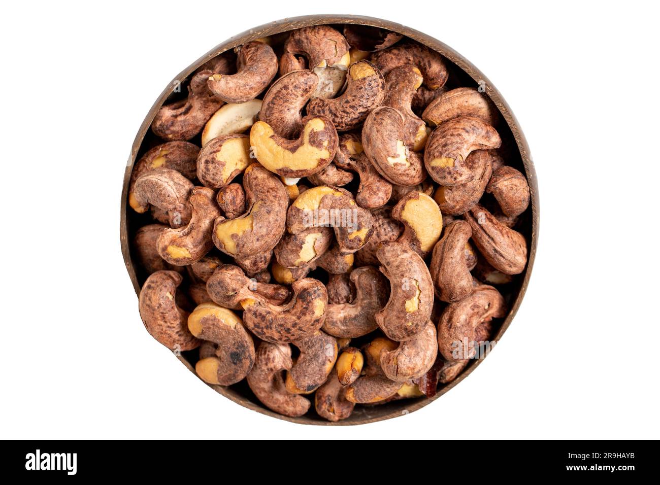 Roasted cashews isolated on white background. Cashews in a coconut bowl