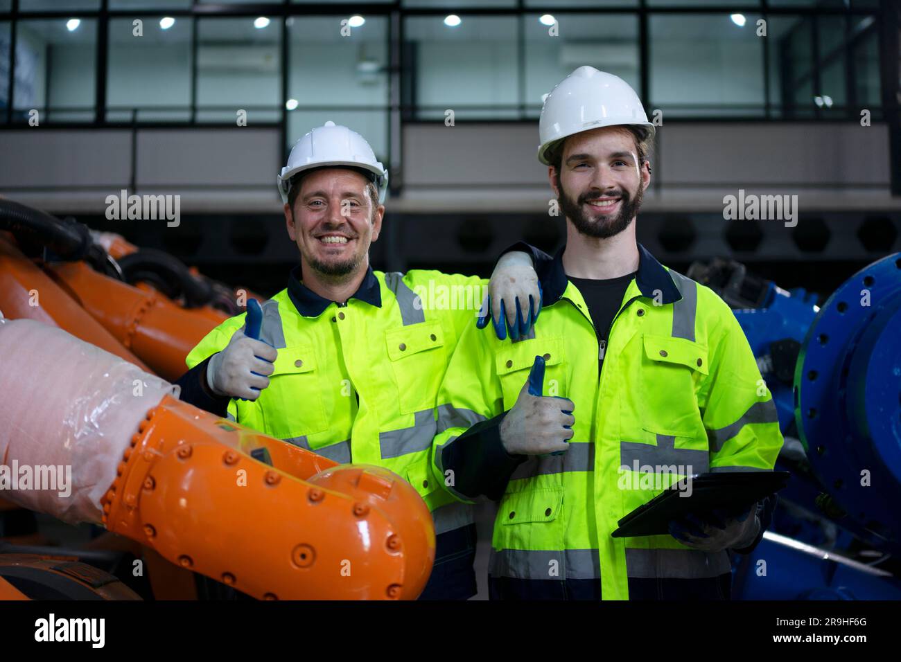Engineer work at robotic arm factory. Technology and engineering concept. Stock Photo