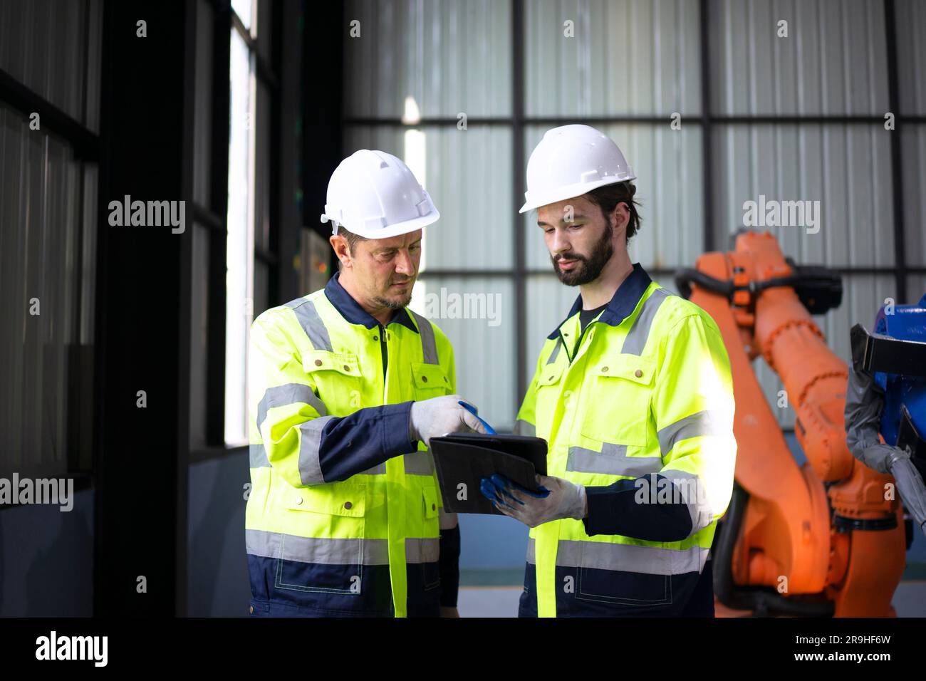 Engineer work at robotic arm factory. Technology and engineering concept. Stock Photo
