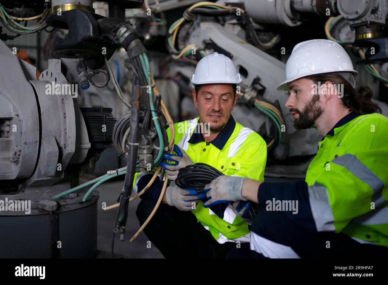 Engineer work at robotic arm factory. Technology and engineering concept. Stock Photo