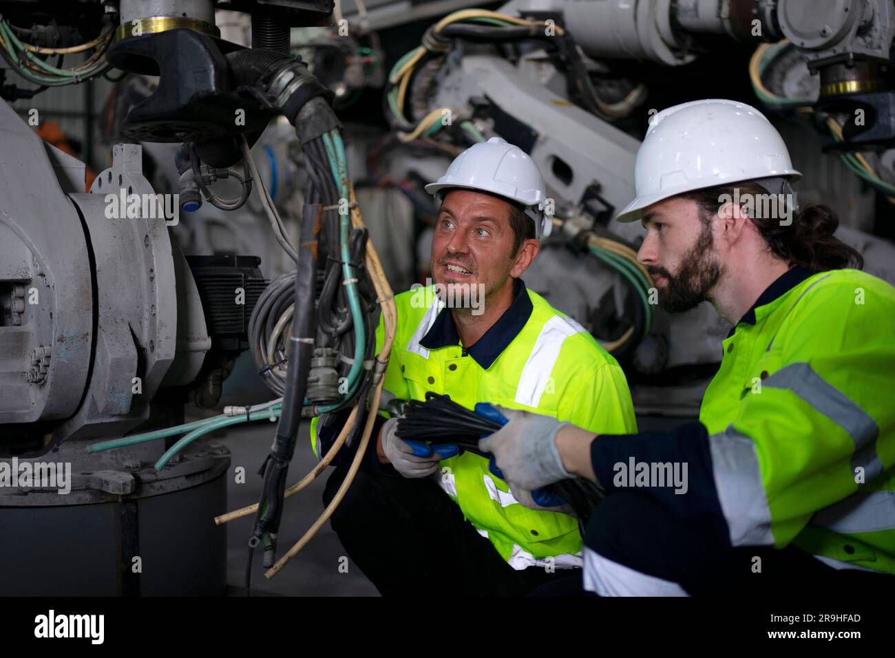 Engineer work at robotic arm factory. Technology and engineering concept. Stock Photo