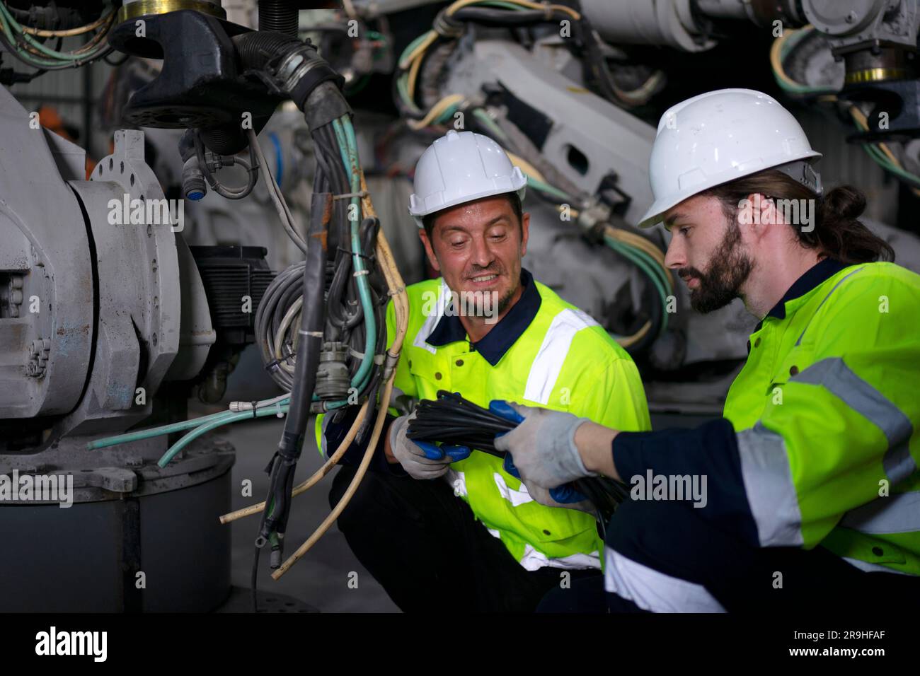 Engineer work at robotic arm factory. Technology and engineering concept. Stock Photo