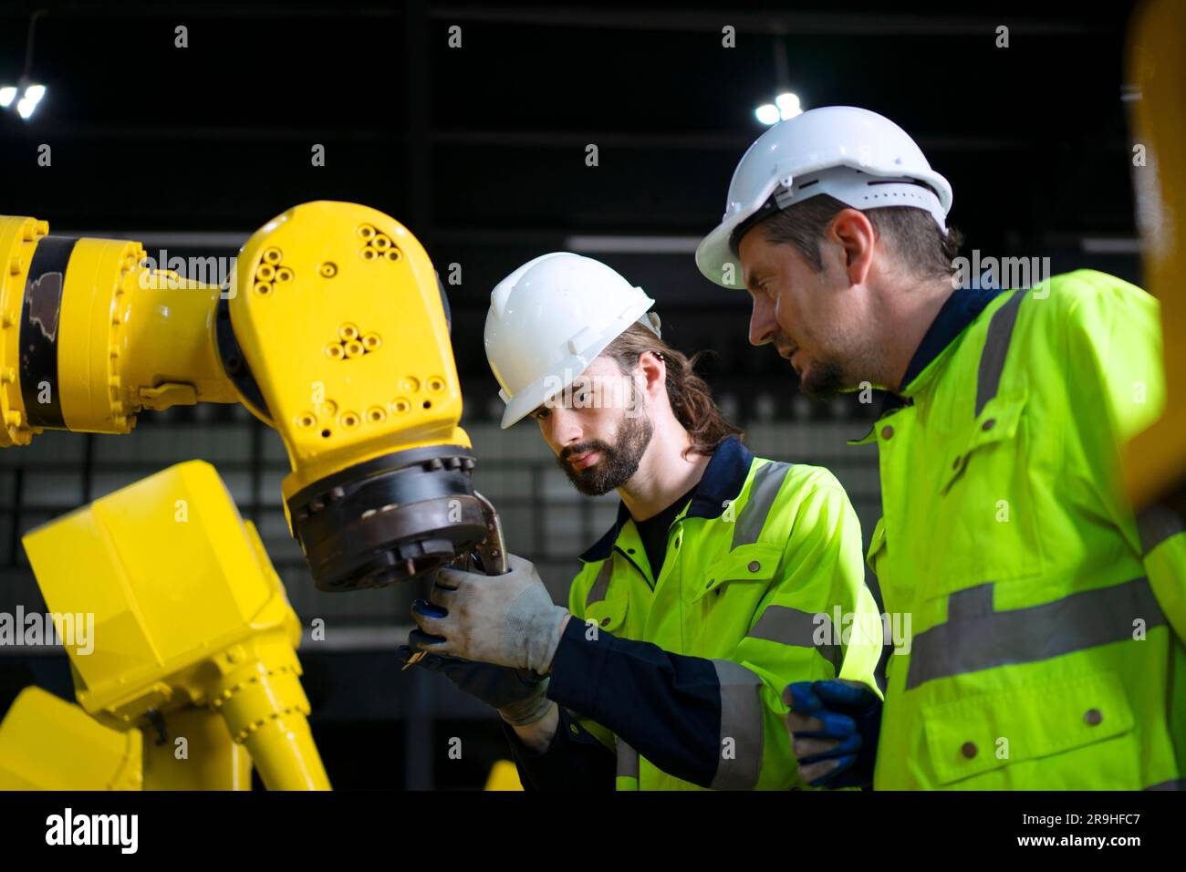 Engineer work at robotic arm factory. Technology and engineering concept. Stock Photo