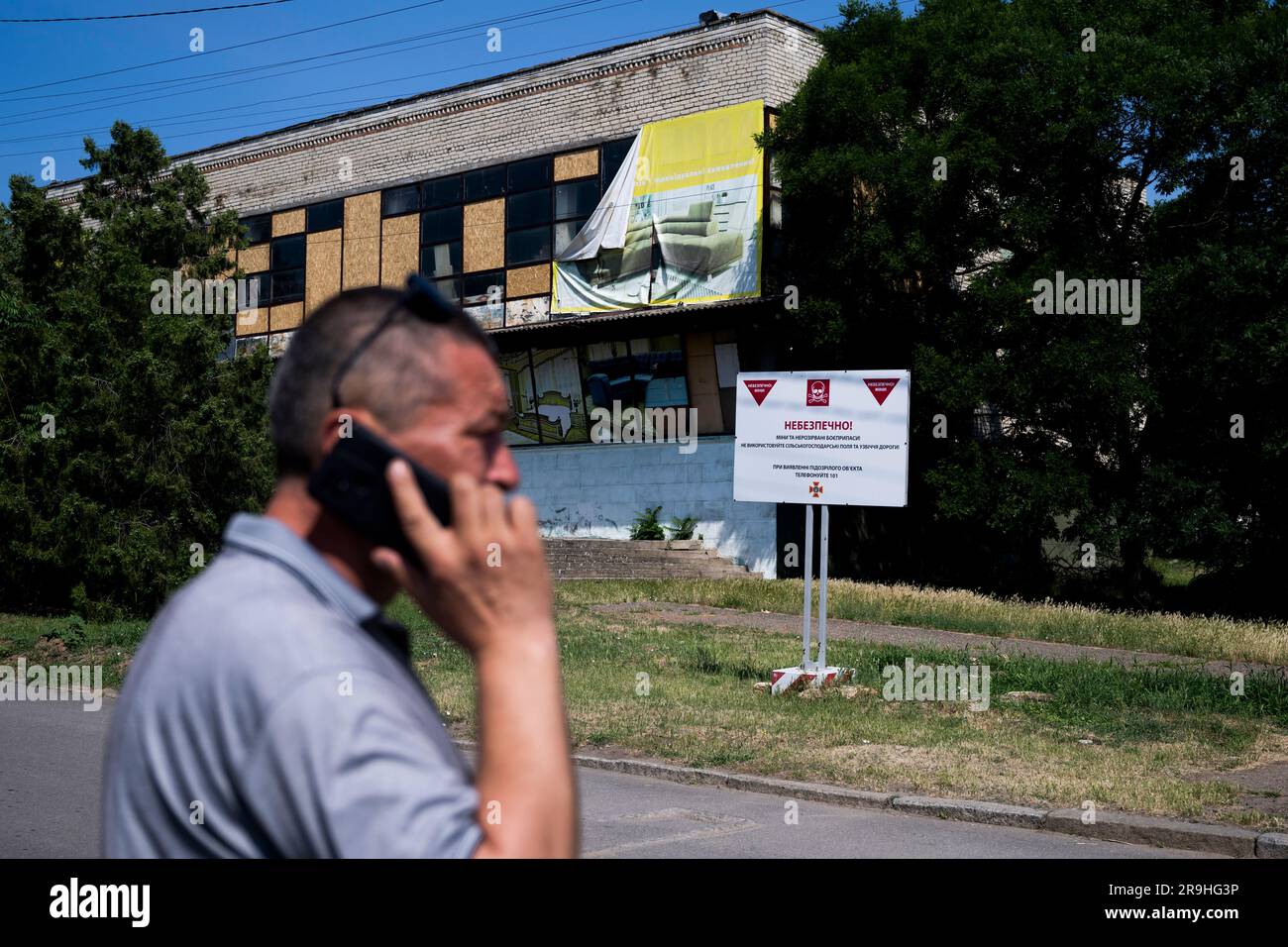 Snihurivka, Ukraine. 23rd June, 2023. A man walks past a sign warning
