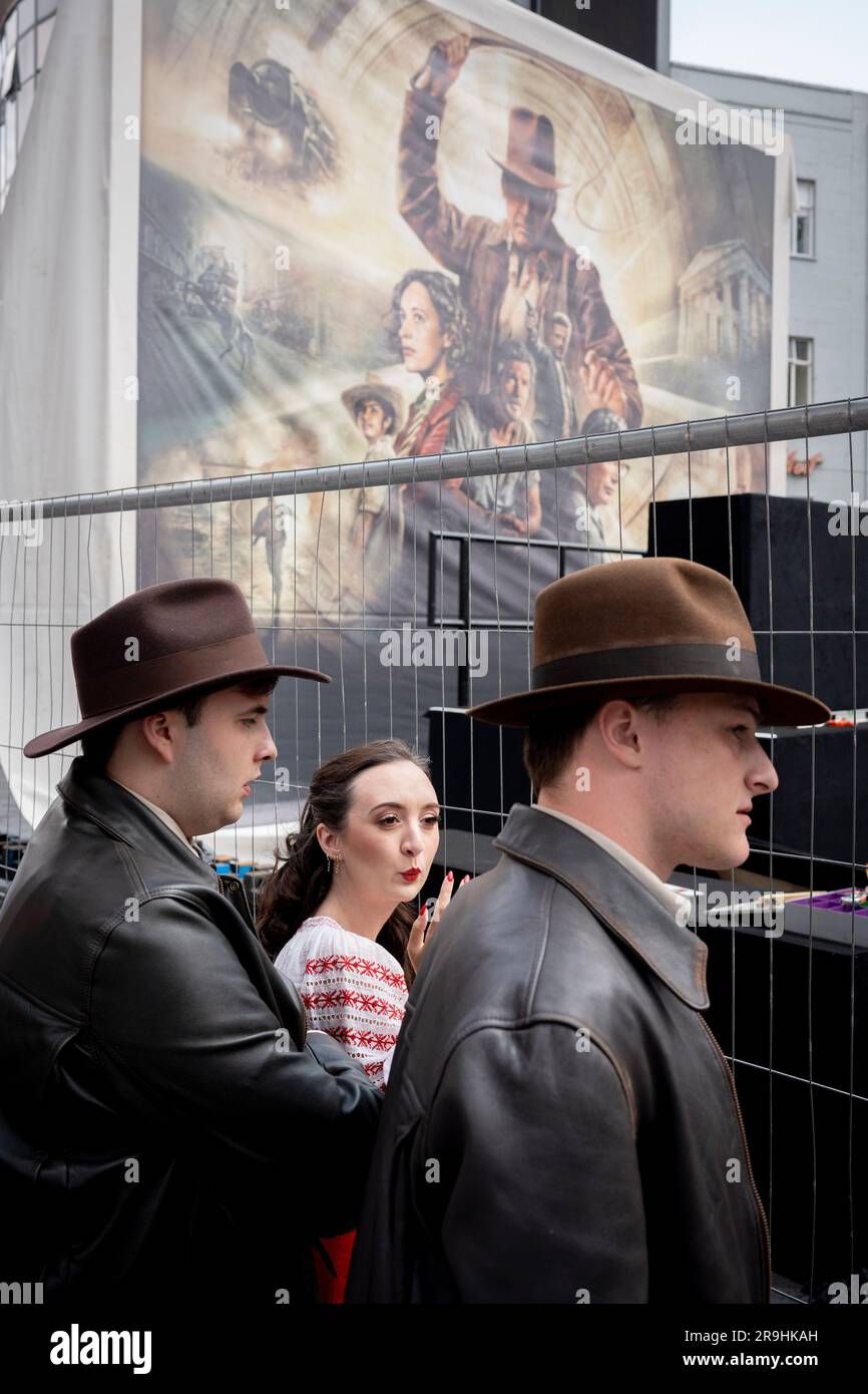 Fans of actor Harrison Ford gather beneath a large billboard erected before the premiere of 'Indiana Jones and the Dial of Destiny', in Leicester Square, on 26th June, in London, England. Stock Photo