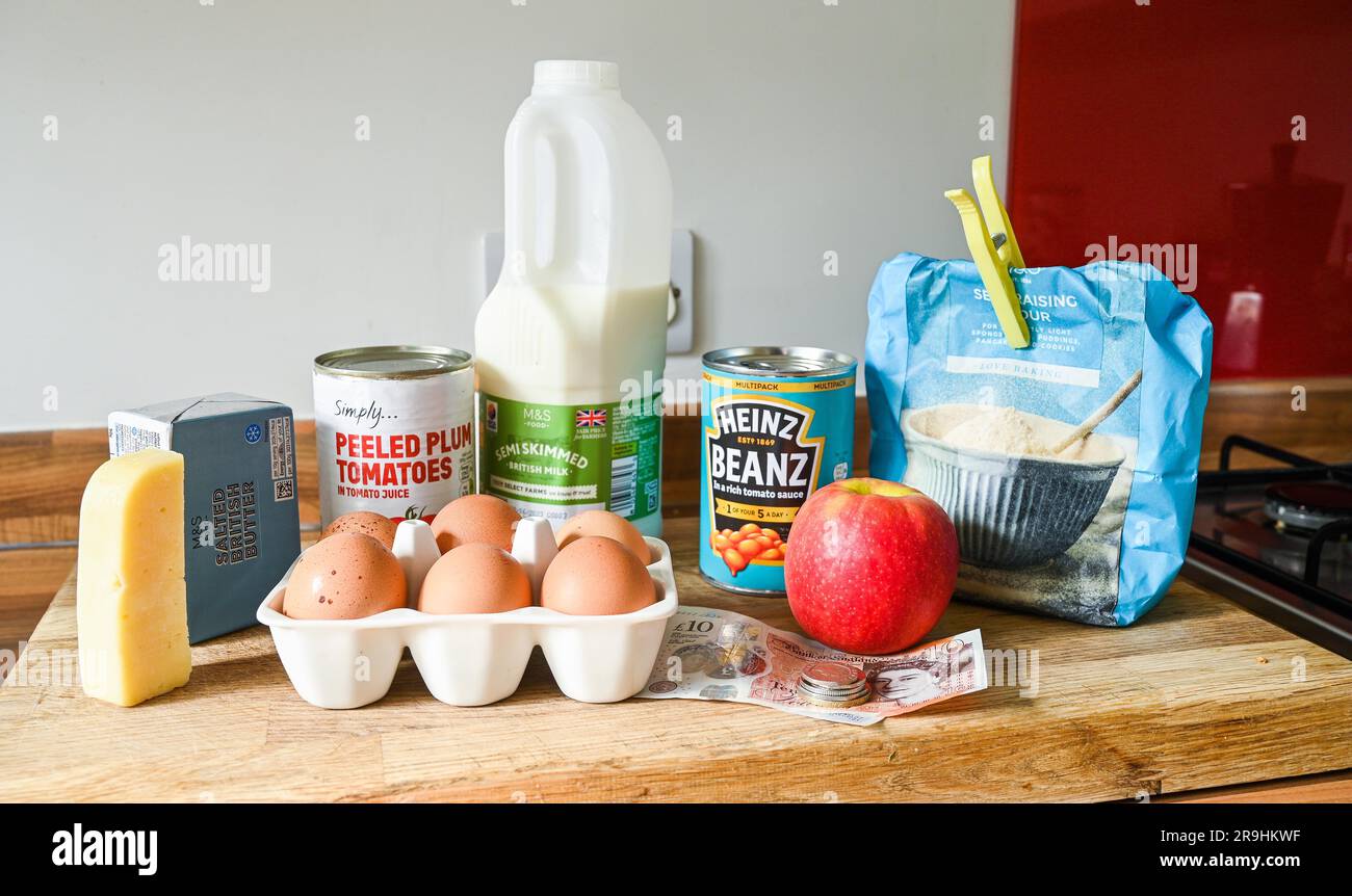 Cost of Living Food Items for typical UK household including Heinz Baked Beans milk flour butter cheese and eggs with cash for shopping bill Stock Photo