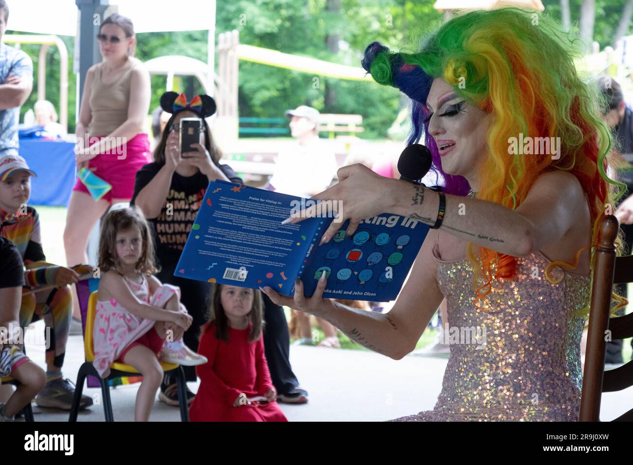 A drag performer reads a book to Children called Fitting In, about inclusivity. In Lewisboro, Westchester at a Pride event. June 2023. Stock Photo