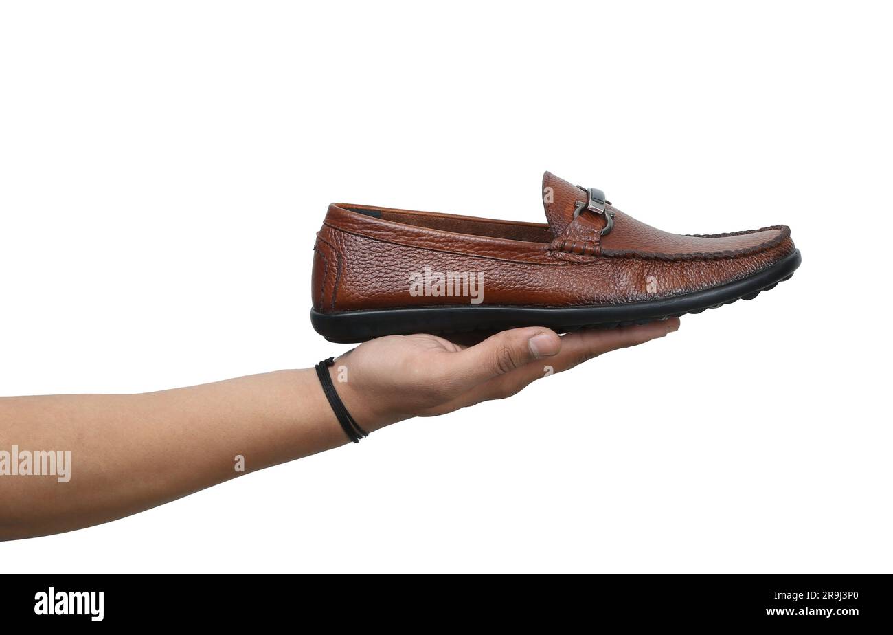 tan leather loafer holds in man hand Stock Photo