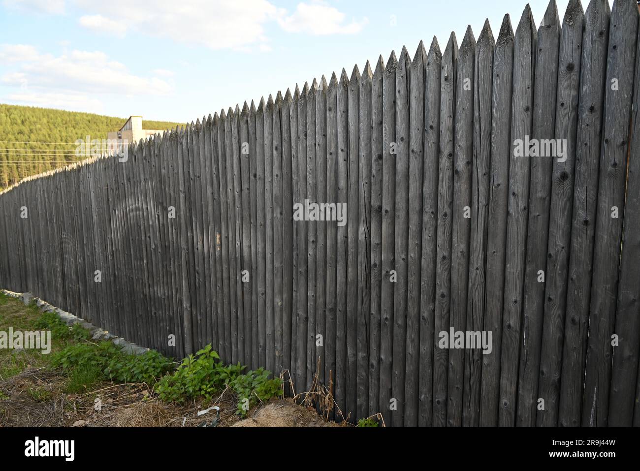 an old gray wooden fence made of logs with sharp ends Stock Photo - Alamy